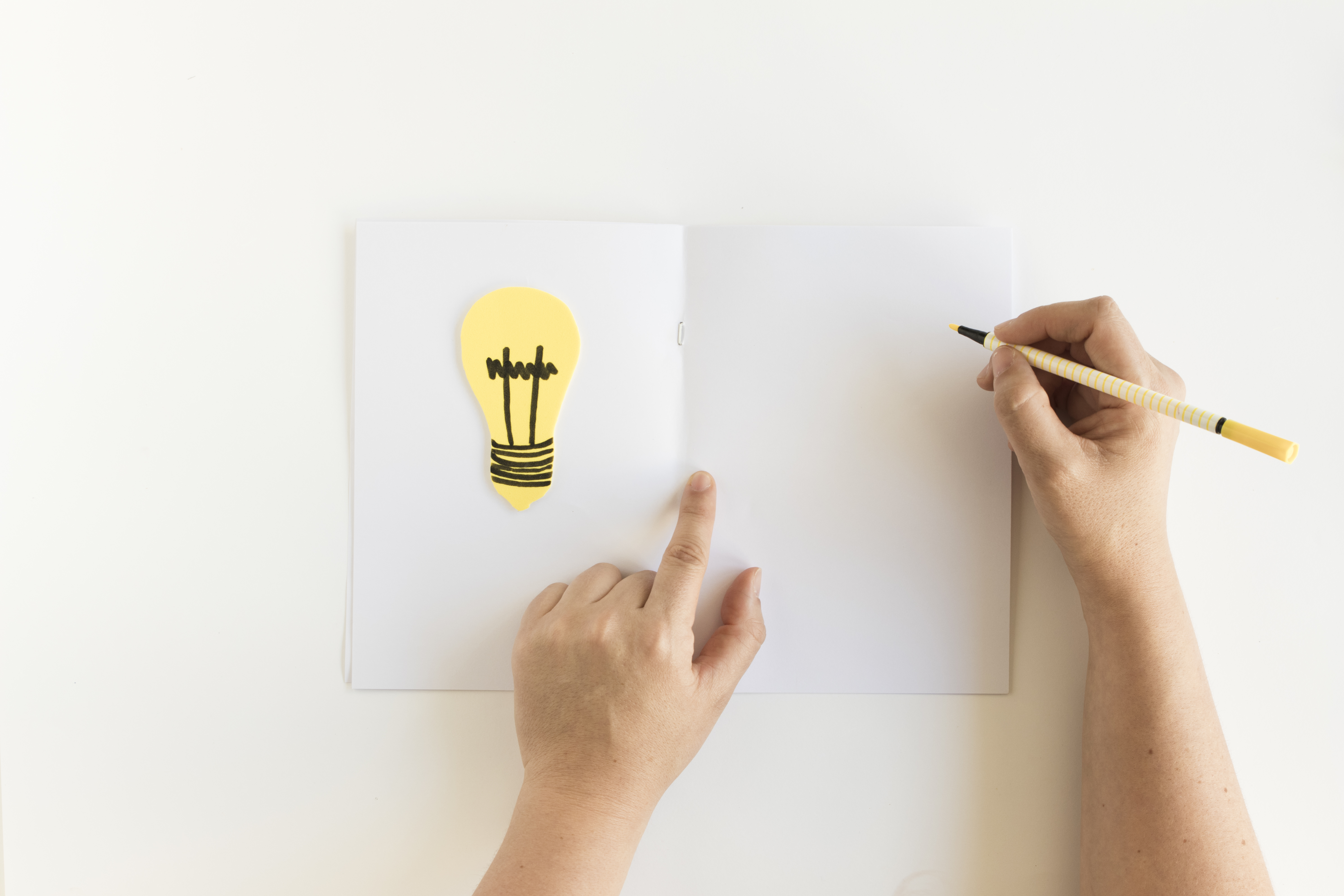 human-hand-writing-card-with-light-bulb